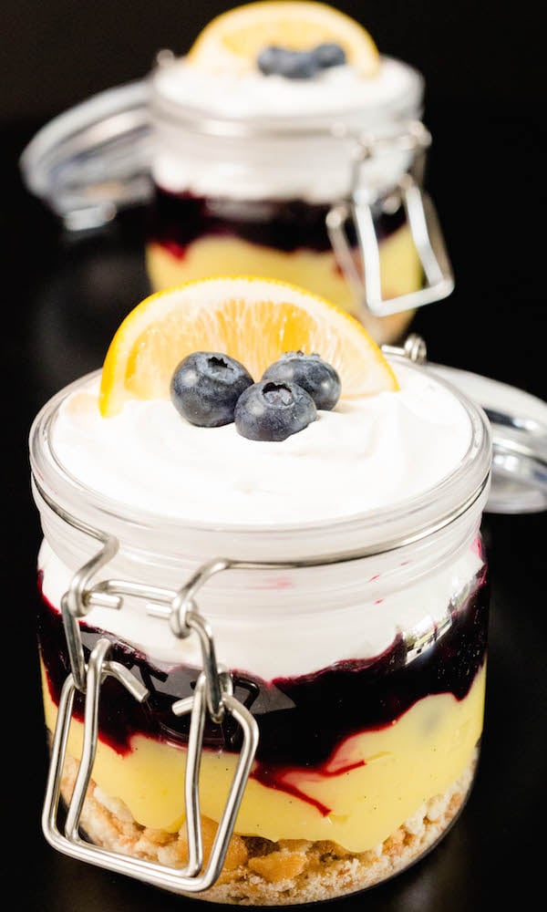 Two Meyer lemon & blueberry Parfaits on a black background.