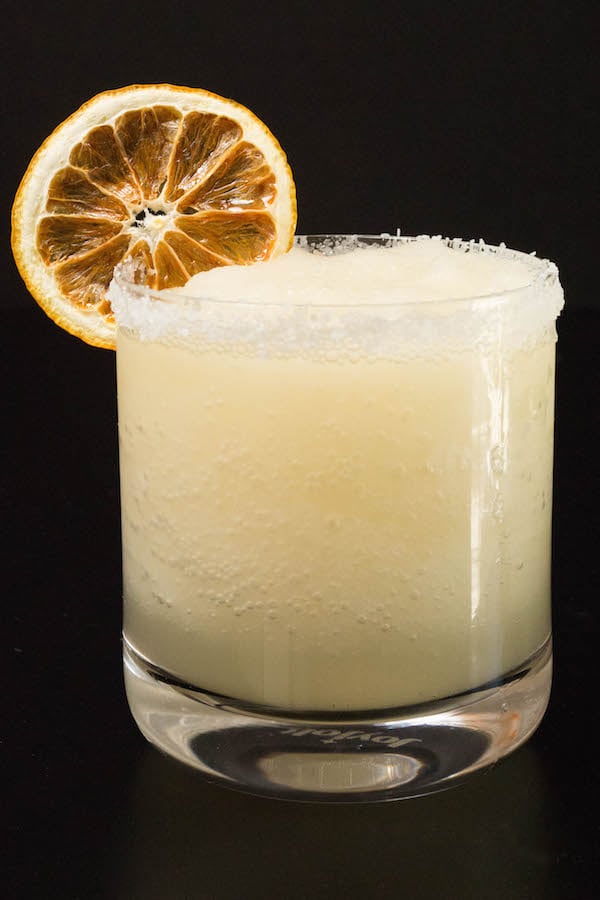 A Meyer lemon margarita in a lowball glass with a dehydrated lemon garnish.