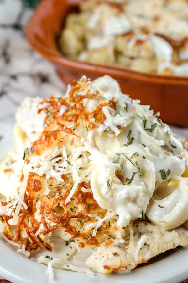 Close-up of single serving of a tortellini pasta bake covered in cheese