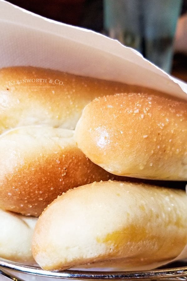 Close up of 4 copycat Olive Garden breadsticks wrapped together in a white dish towel.