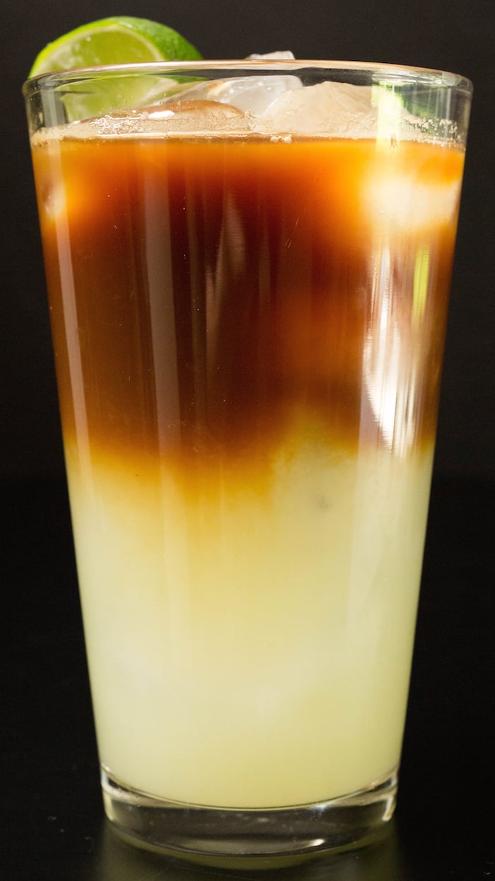 A layered coffee drink with lime juice mixture on the bottom and espresso on top.