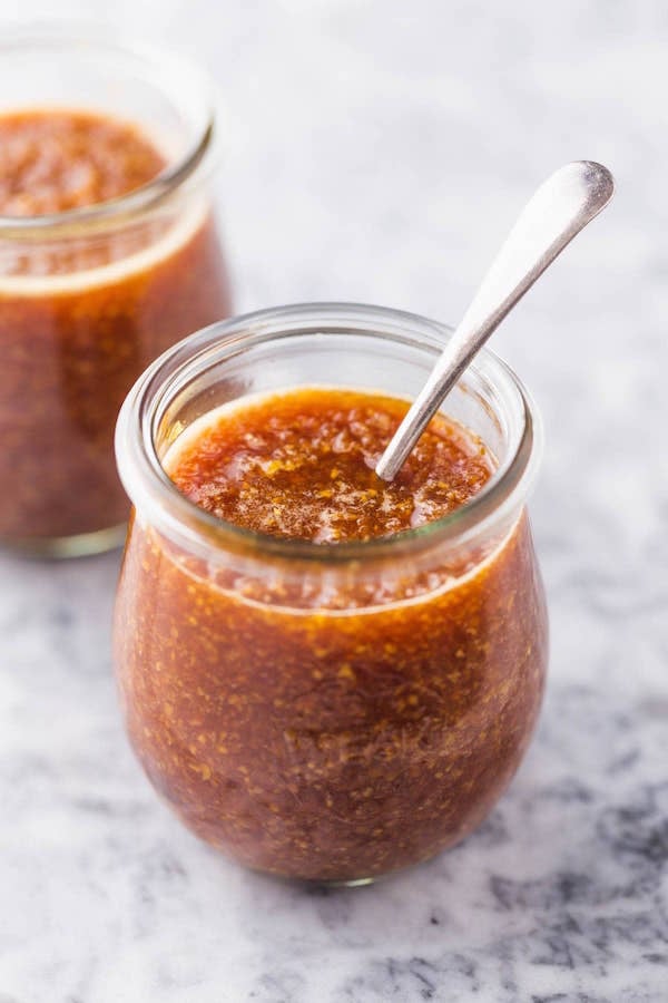 Medium shot of brown Benihana Ginger sauce in a small jar with a metal spoon