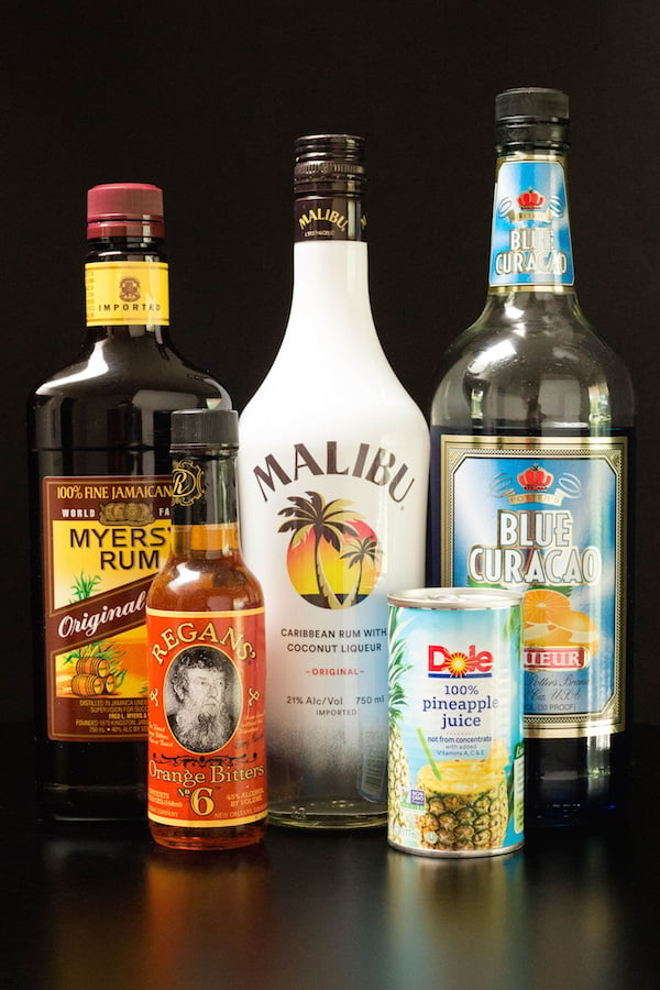 Qurantiki cocktails on a black background - Dark rum, Malibu Rum, Blue Curacao, Orange Bitters, Dole Pineapple Juice.