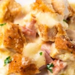 Close up of a piece of Chicken Cordon Bleu Casserole on a white dish