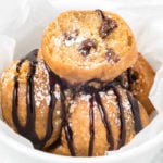 A bowl of fried cookie dough balls covered in chocolate syrup