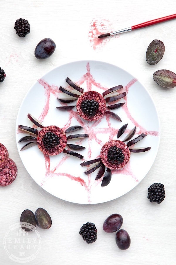 Rice cakes dyed purple with blackberries and sliced grapes added for legs so that they look like spiders.