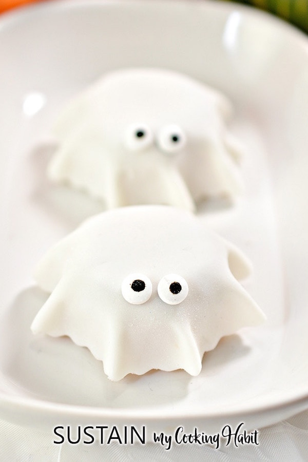 Mini muffins have white fondant draped over them and candy eyes to look like ghosts.
