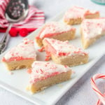 Six candy cane cookie bars sit on a white platter