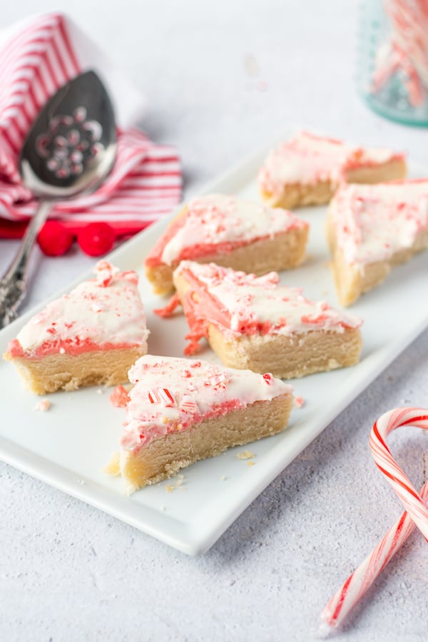 Six candy cane cookie bars sit on a white platter