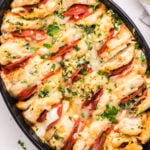 An oval casserole dish that's filled with canned biscuits stuffed with pizza toppings to make a casserole.