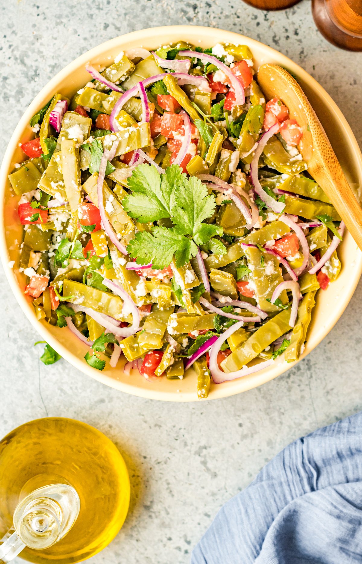 Overhead view of cactus salad in a large yellow serving bowl