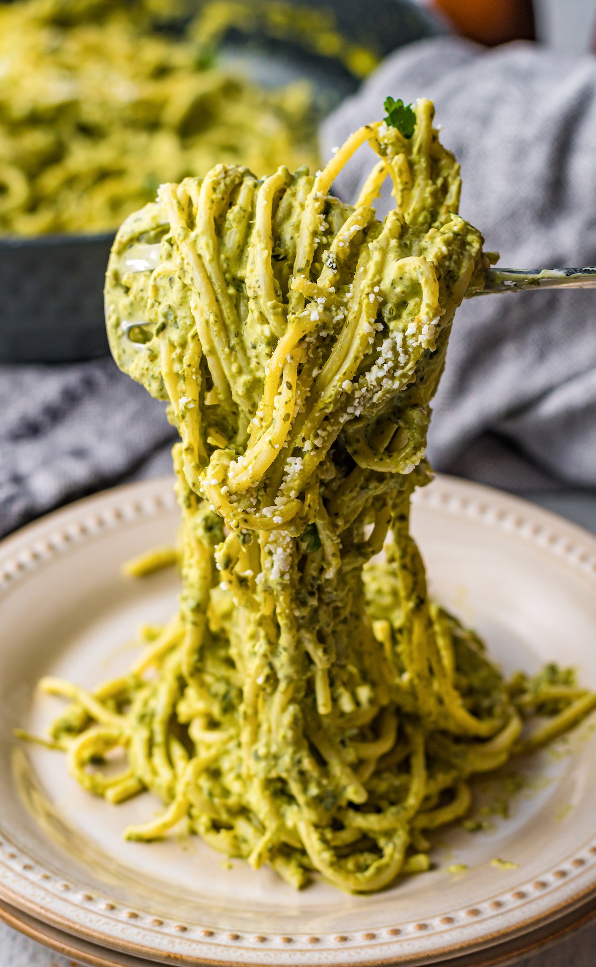 A fork twirls green Mexican spaghetti over a plate