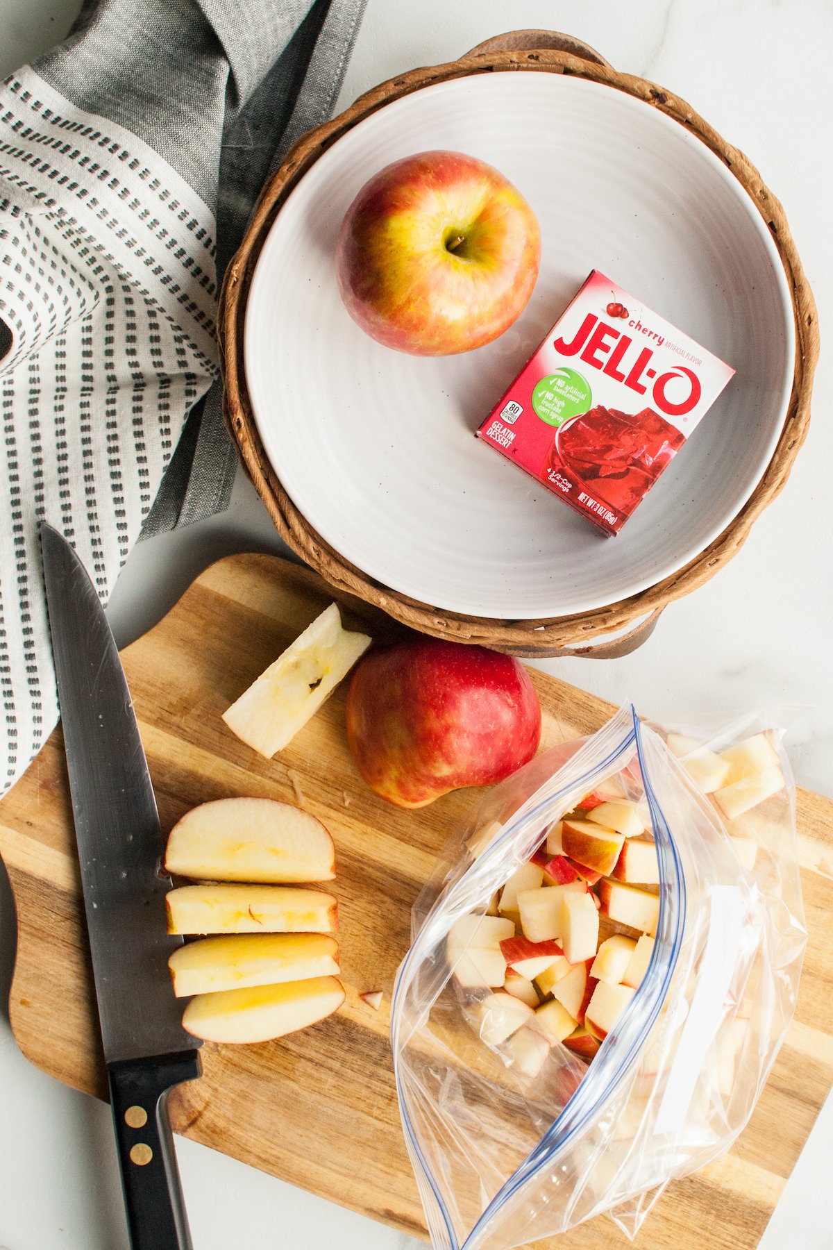 Chopped apples being put into a Ziploc bag.