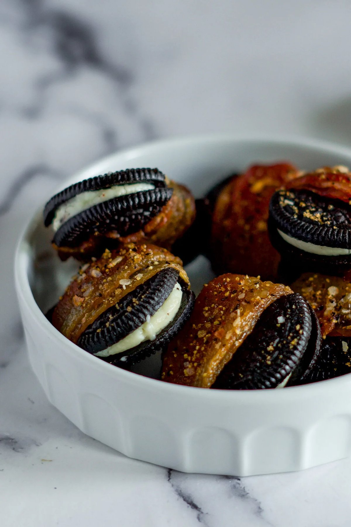 A bowl of Oreo cookies that have been wrapped in bacon, then smoked in the smoker.