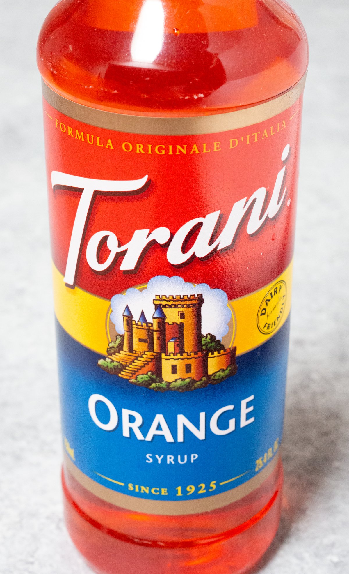 A bottle of Torani Orange Syrup on a light background.