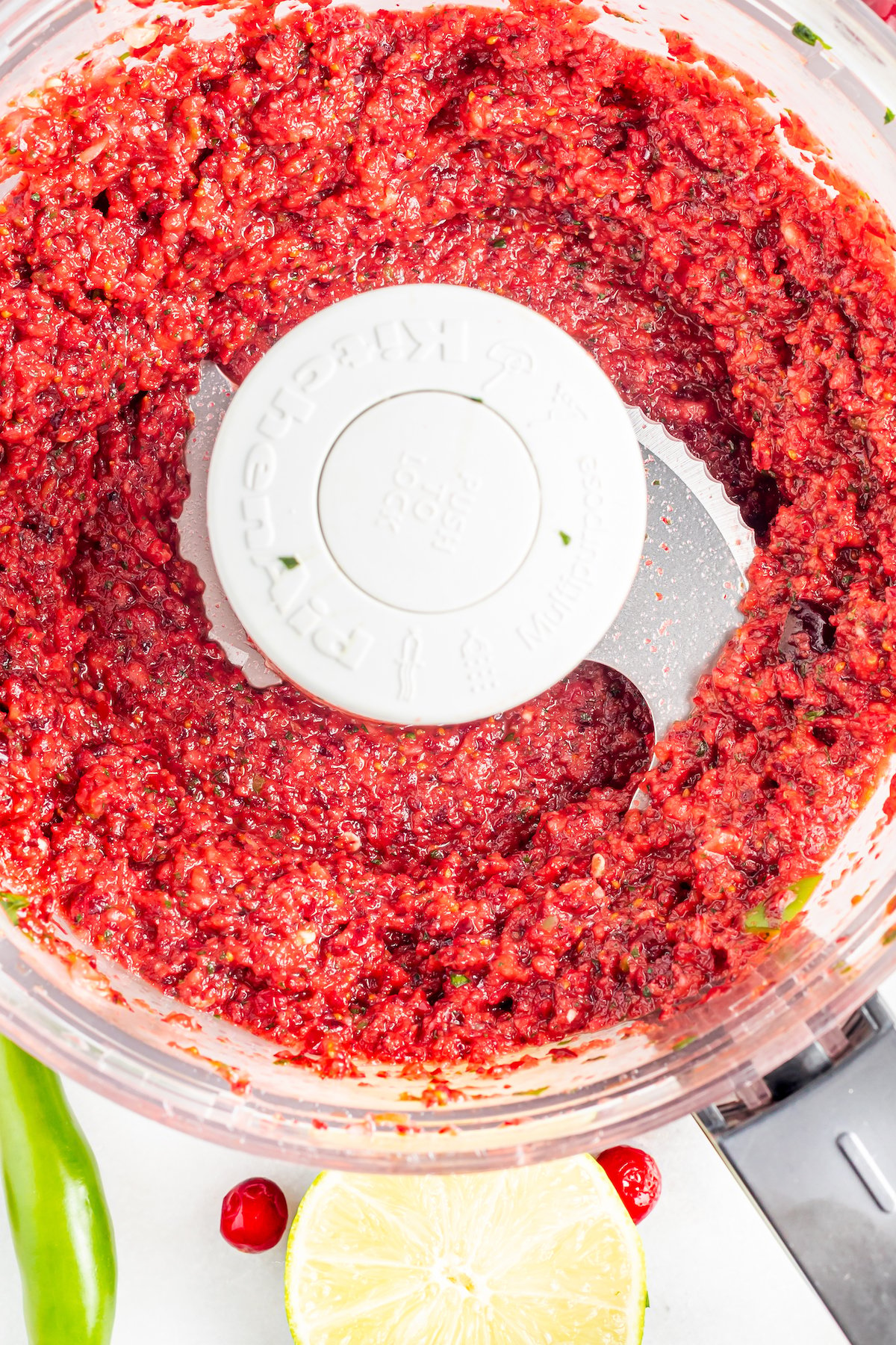 Overhead view of a food processor after the cranberry salsa has been pureed. 