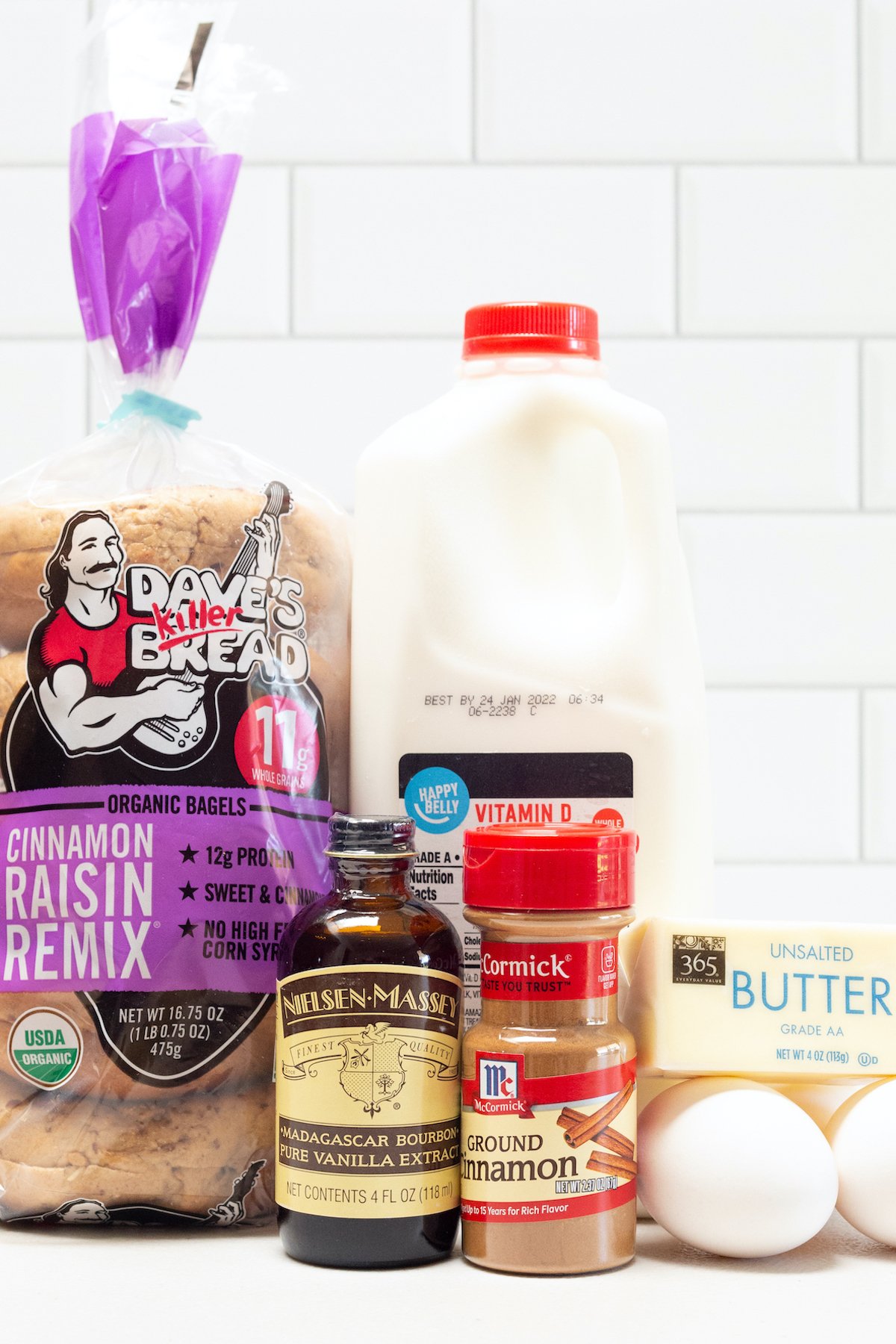 All the ingredients to make french toast bagels - bagels, vanilla extract, milk, cinnamon, eggs, butter.