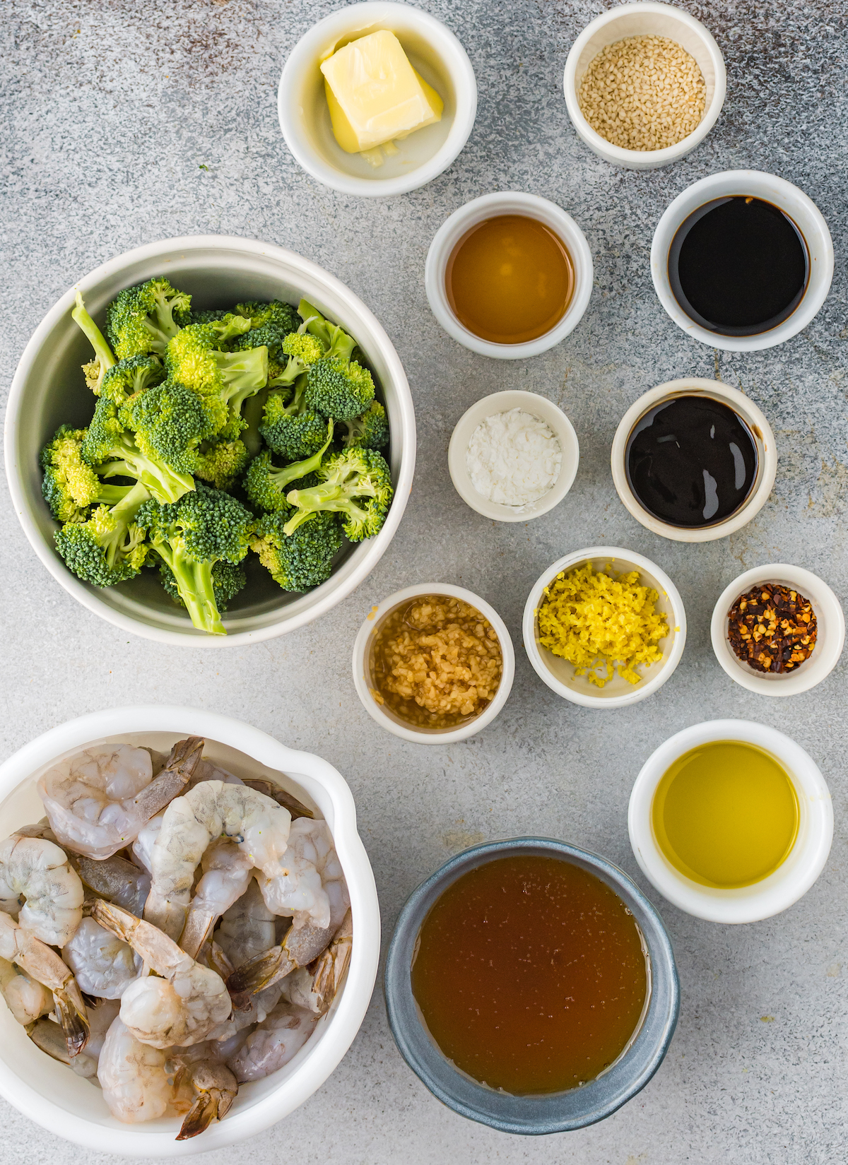Overhead view of prep dishes that contain all the ingredients for shrimp and broccoli.