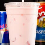 A large plastic cup is filled with a pink Red Bull Italian Soda.