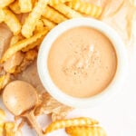 Homemade Zax sauce in a white bowl next to french fries.