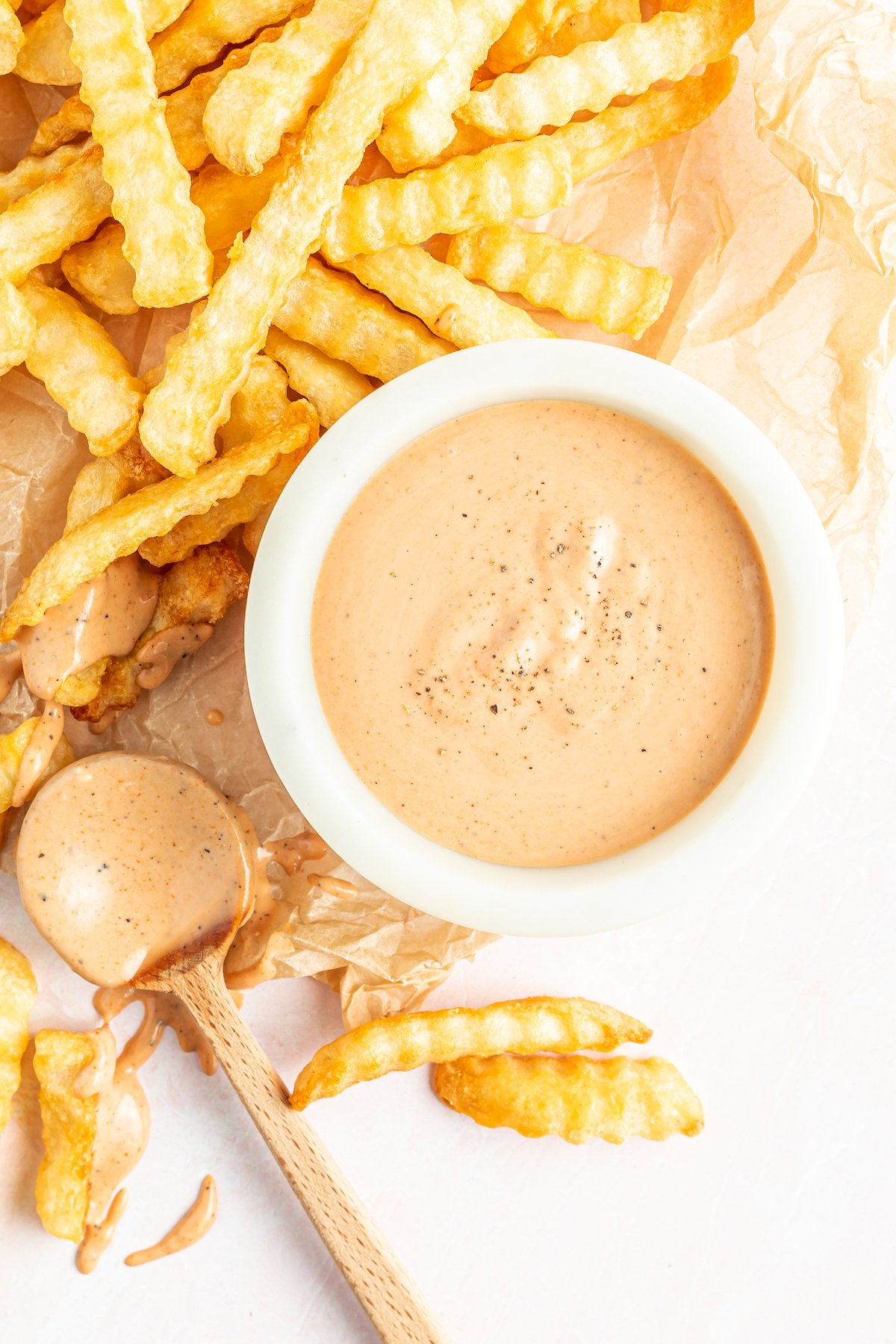 Homemade Zax sauce in a white bowl next to french fries.