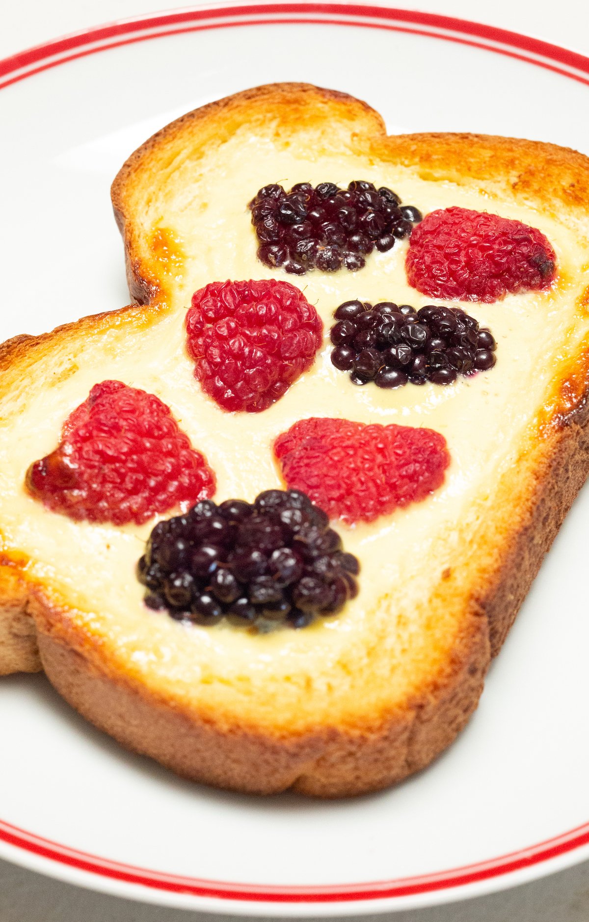 A single piece of air fryer custard toast topped with fresh berries.