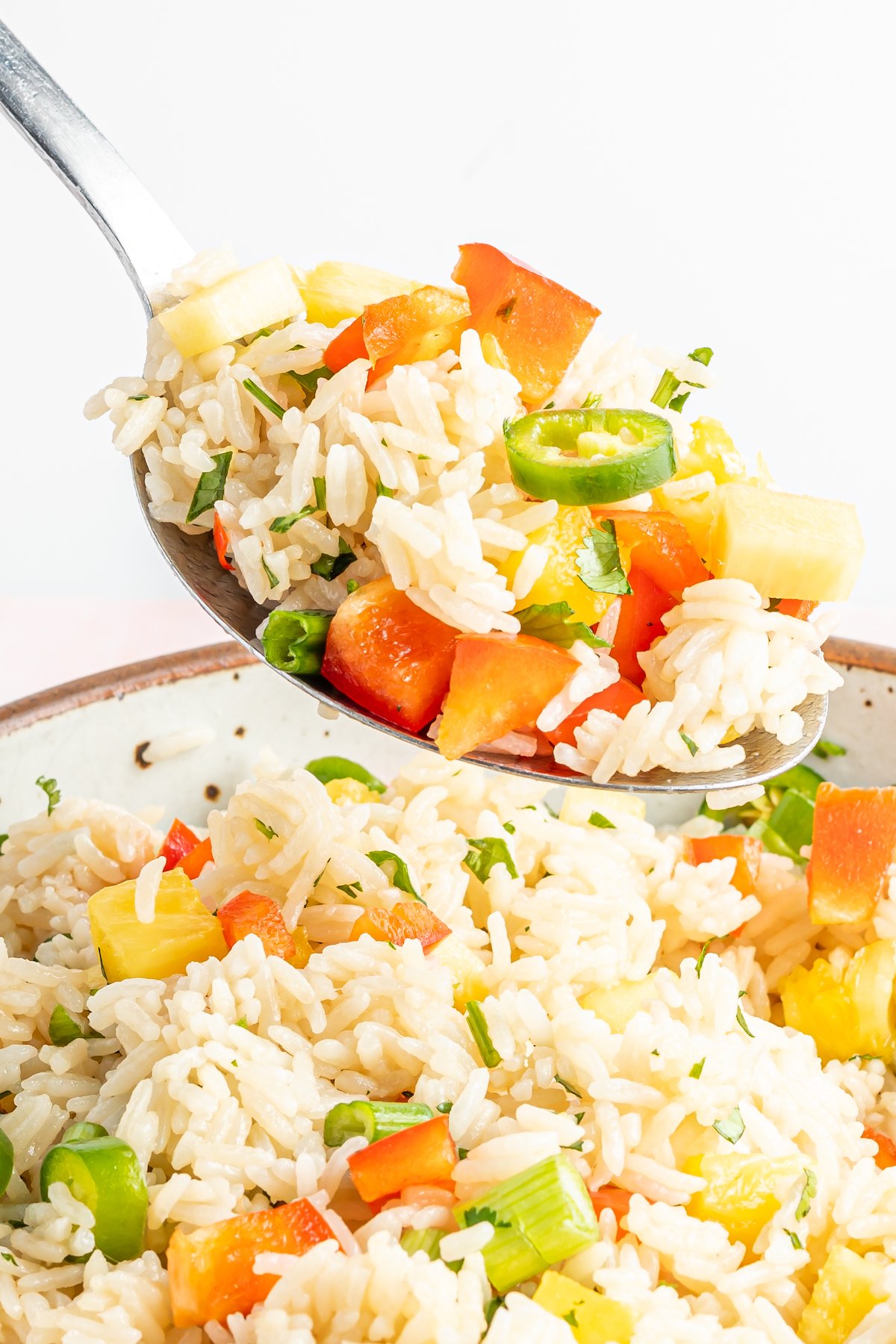 A spoonful of Instant Pot coconut rice over a bowl filled with the rest.