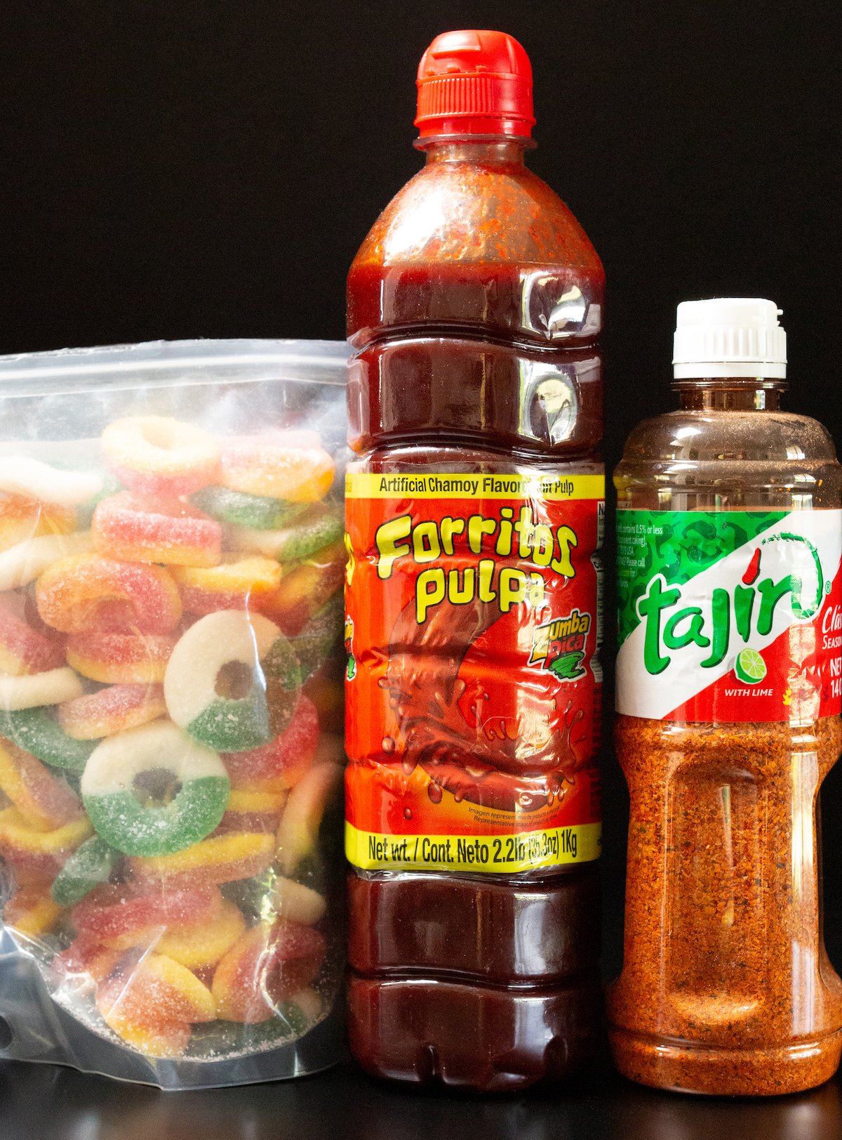 All the ingredients to make spicy Mexican candy - gummy candy, Chamoy, and Tajin.