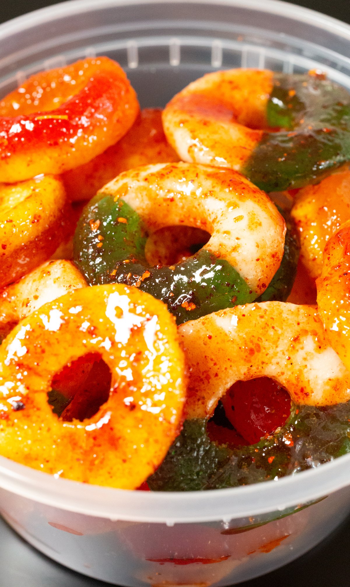 Spicy Mexican Peach Gummy Rings in a plastic container. 