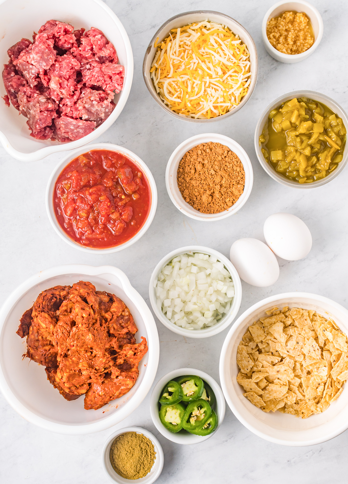 Overhead view of Mexican meatloaf ingredients in serving bowls.