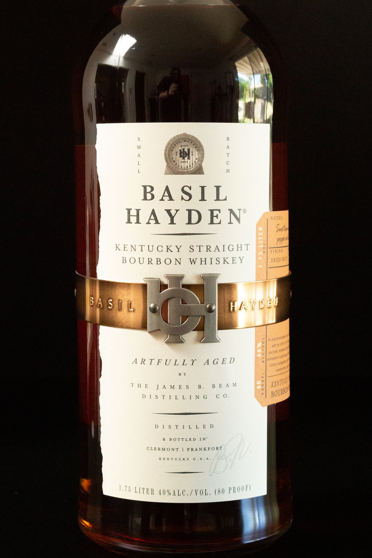 A Basil Hayden whiskey bottle on a black background.