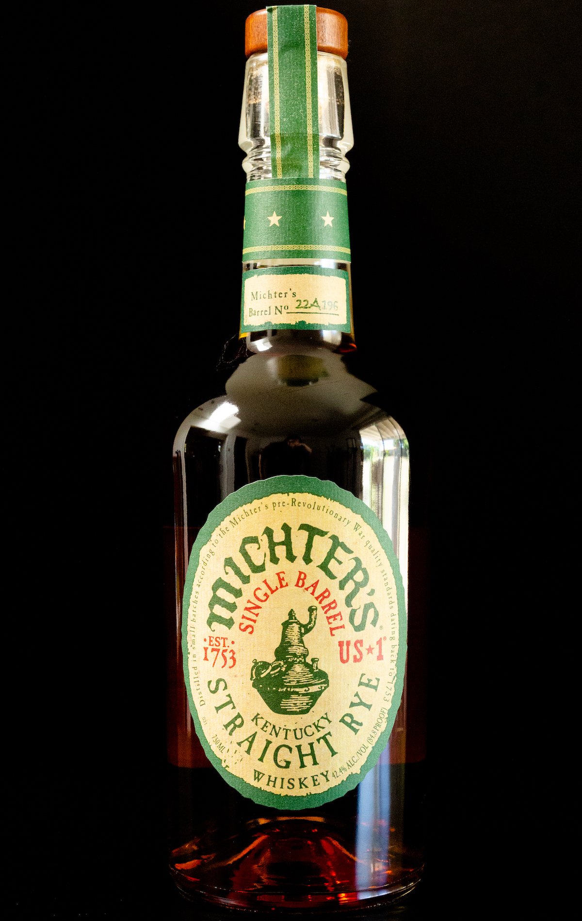 A bottle of Michter's Single Barrel Straight Rye Whiskey on a black background.