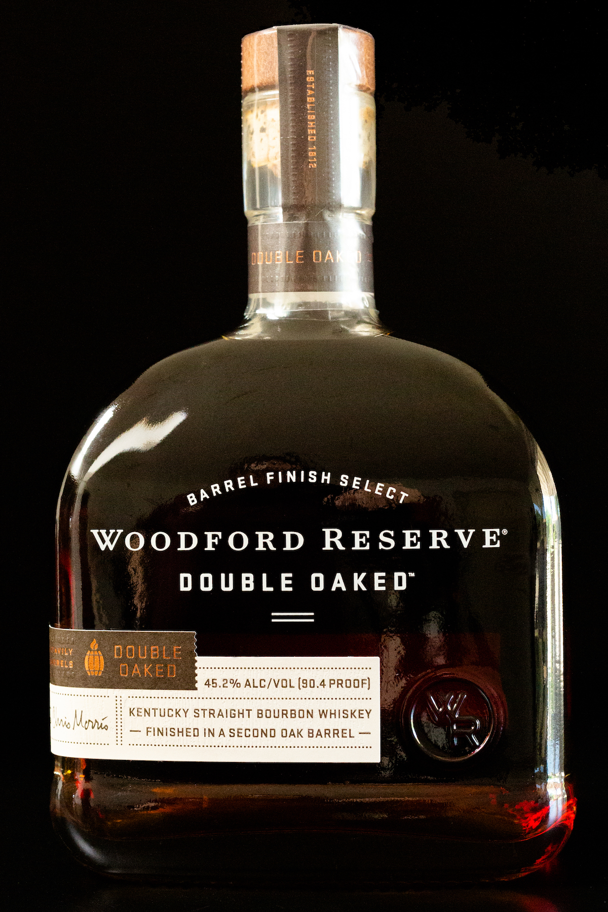 A bottle of Woodford Reserve Double Baked bourbon on a black background.