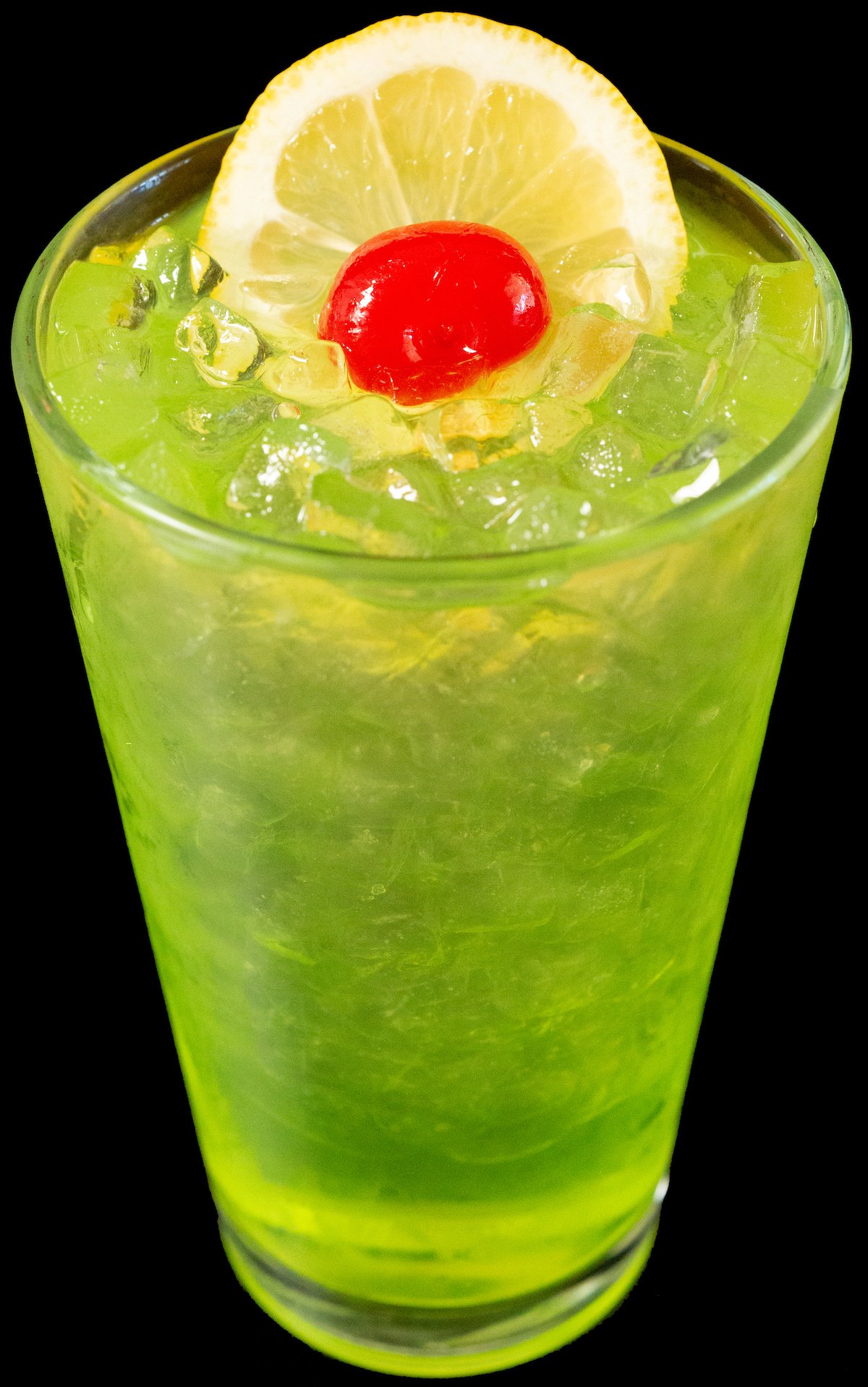 A pint glass filled with a neon green Tokyo Iced Tea cocktail garnished with a lemon wheel and maraschino cherry.