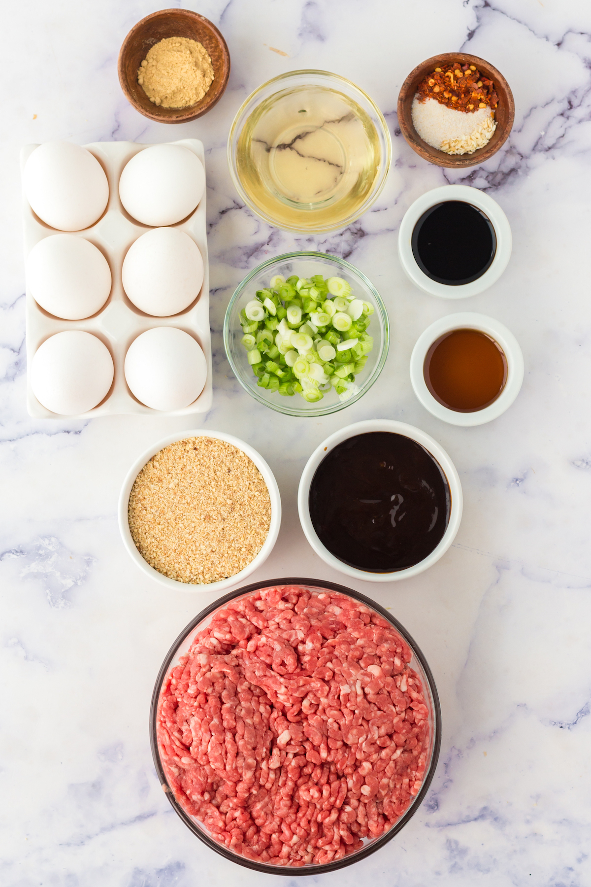 Overhead view of all the ingredient to make Asian Meatballs in prep bowls.