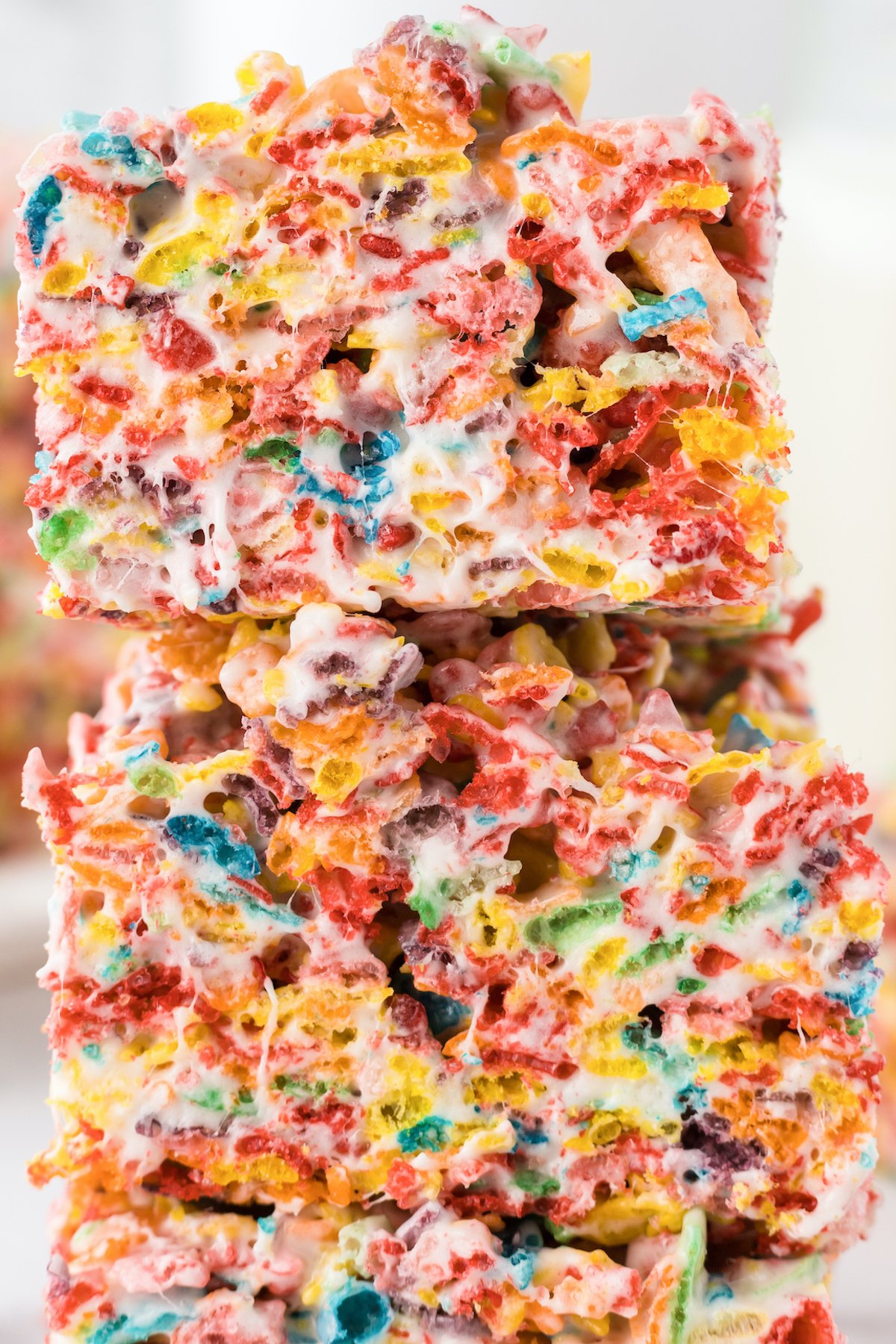 Close up of Fruity Pebbles Rice Krispy squares stacked up on top of each other.