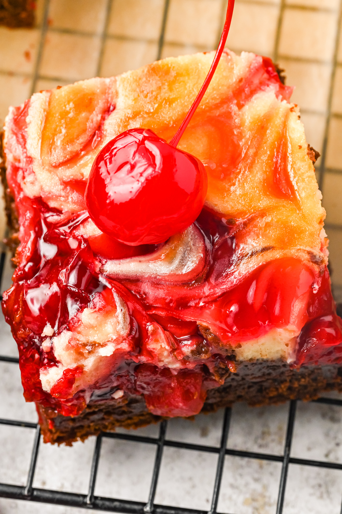 A brownie square that's swirled with cheesecake and cherry pie filling.