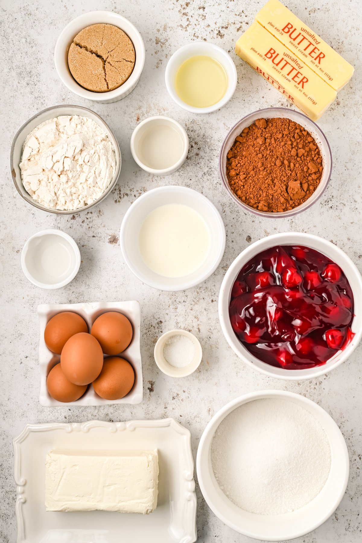 All the ingredients to make cherry cheesecake brownies arranged in prep bowls.