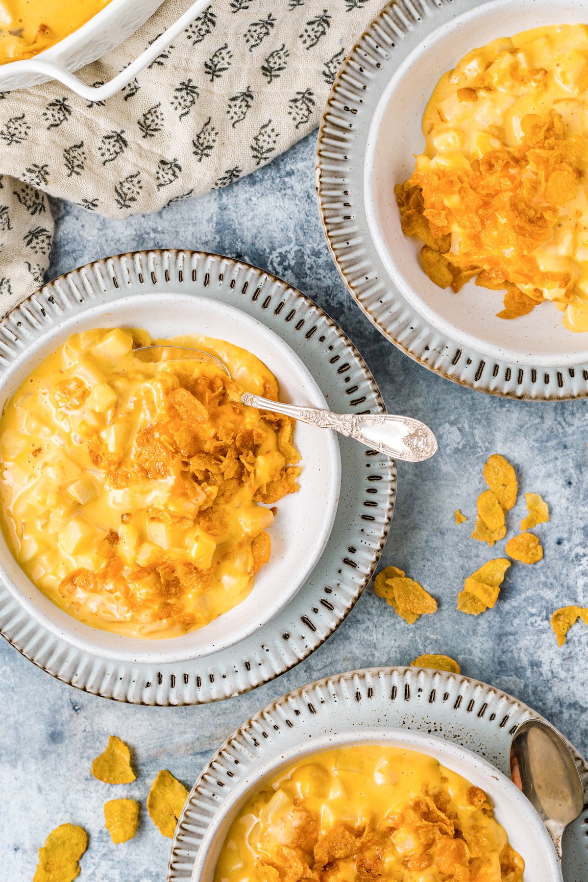 Three soup bowls each filled with a serving of funeral potatoes.