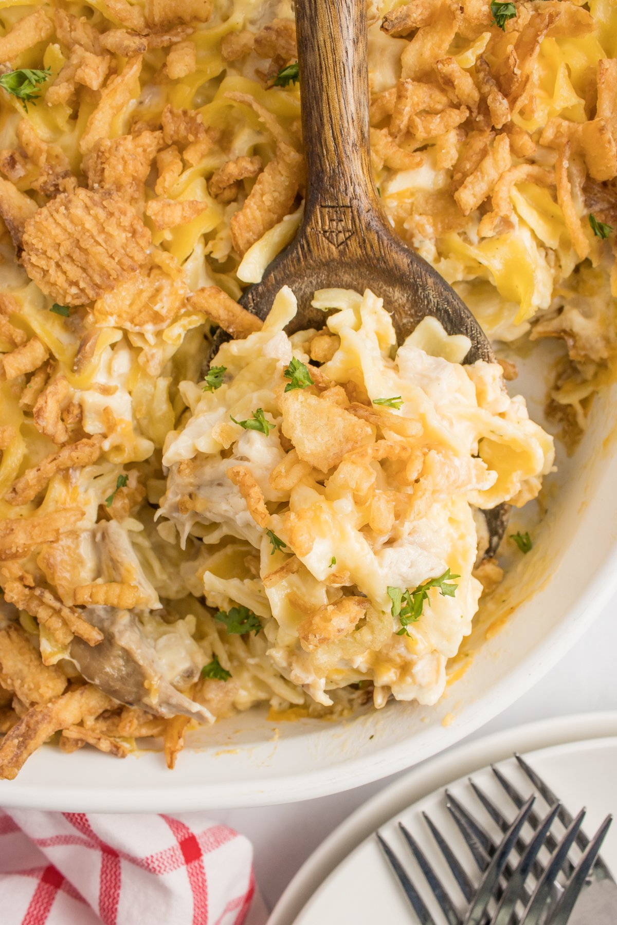 A wooden spoon with a scoop of French onion casserole.