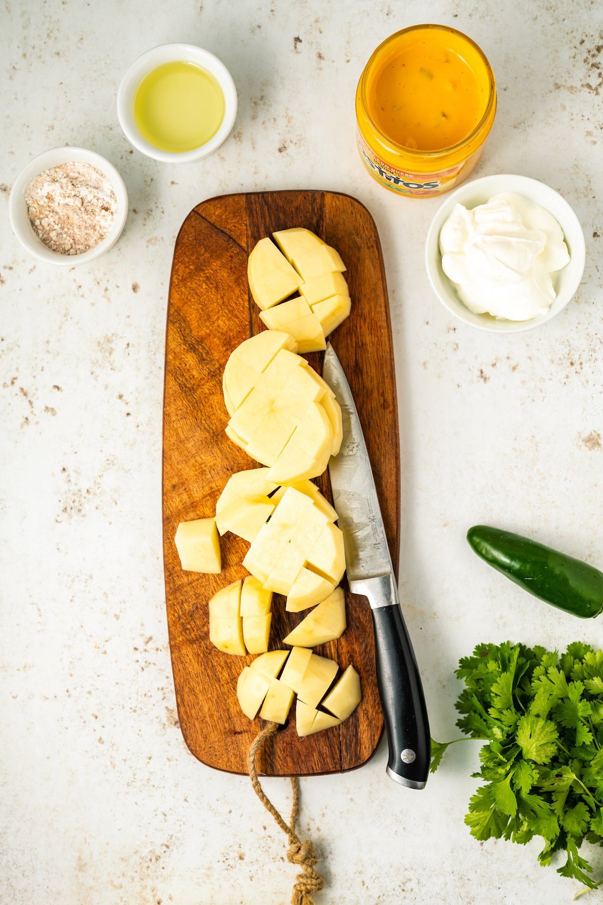 A cutting board with chopped potatoes.