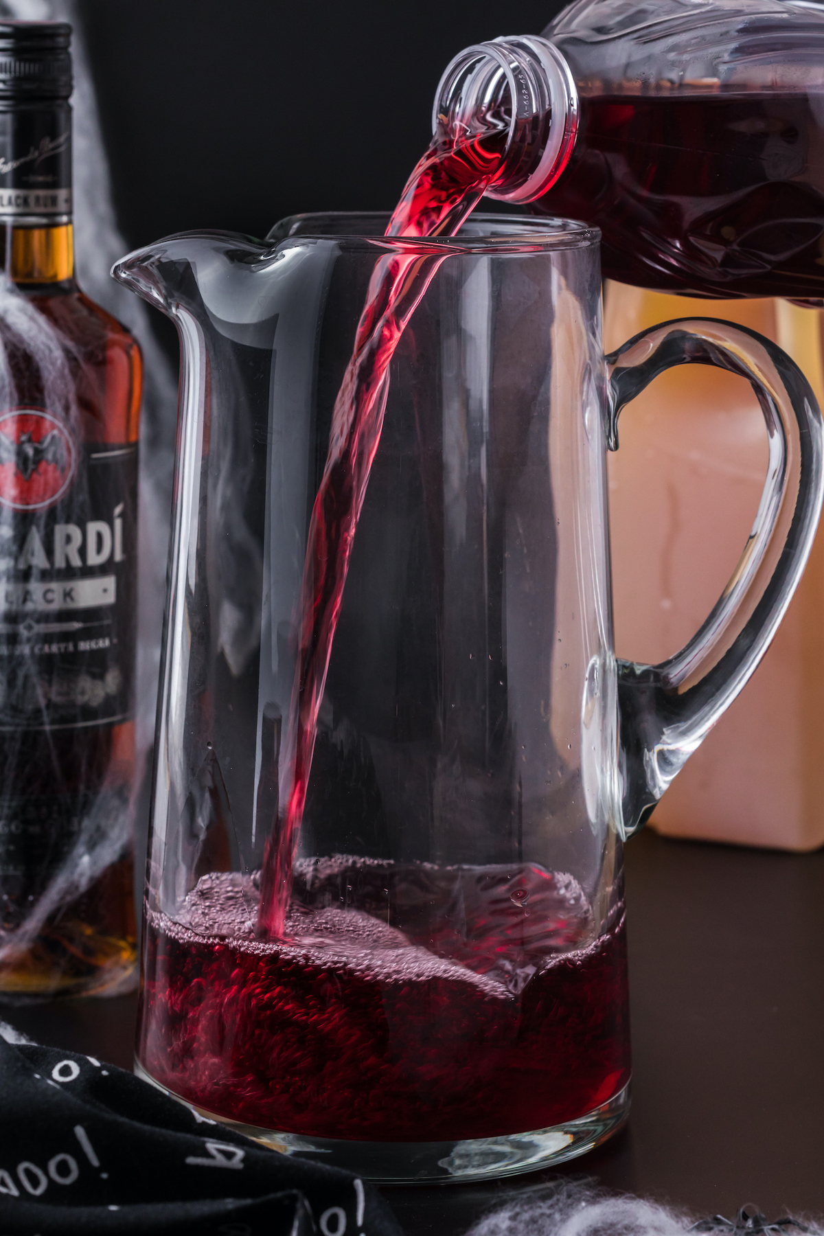 A tall glass pitched being filled with cran-grape juice.