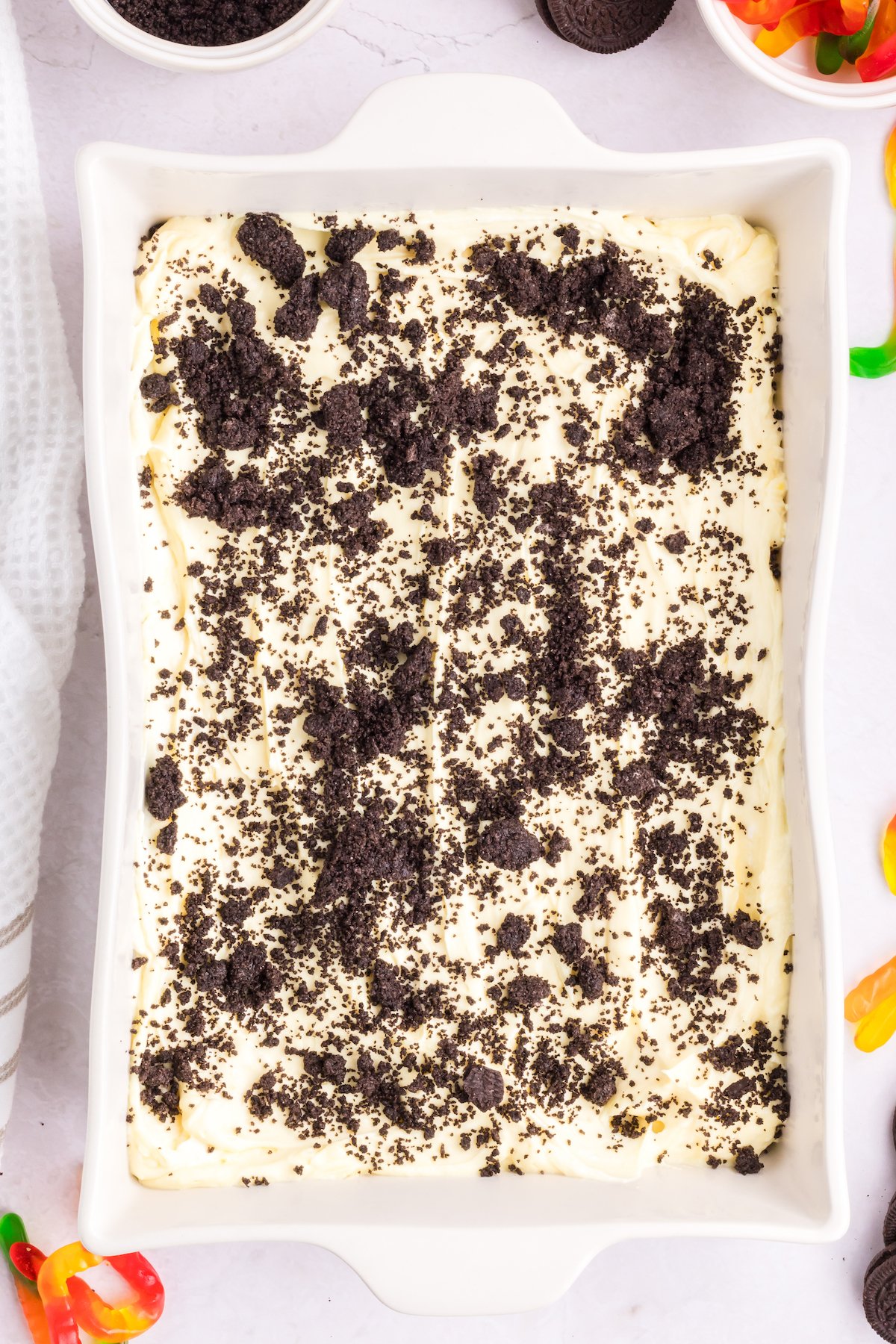 An Oreo dirt cake in a 9x13 pan that has been topped with cookie crumbles.