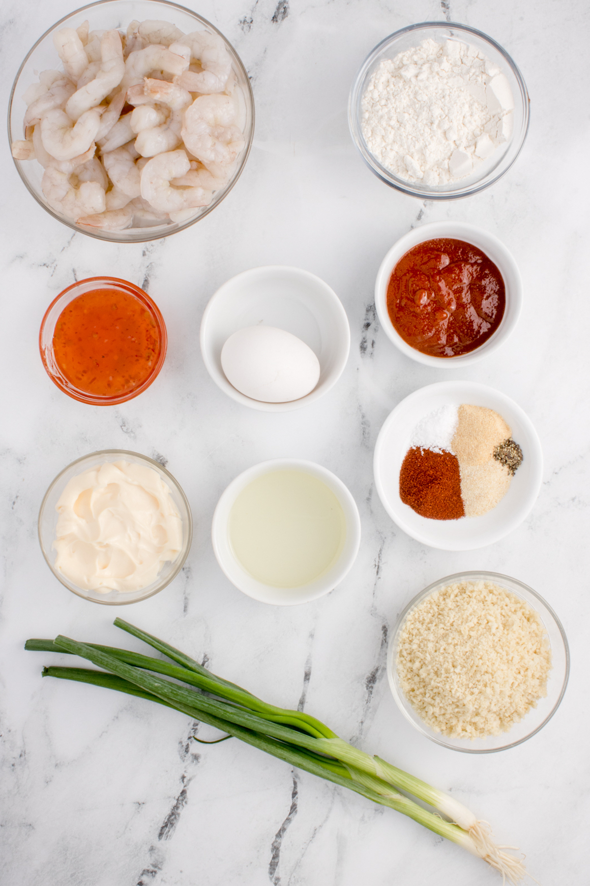 All the ingredients needed to make air fried bang bang shrimp laid out in small prep bowls.