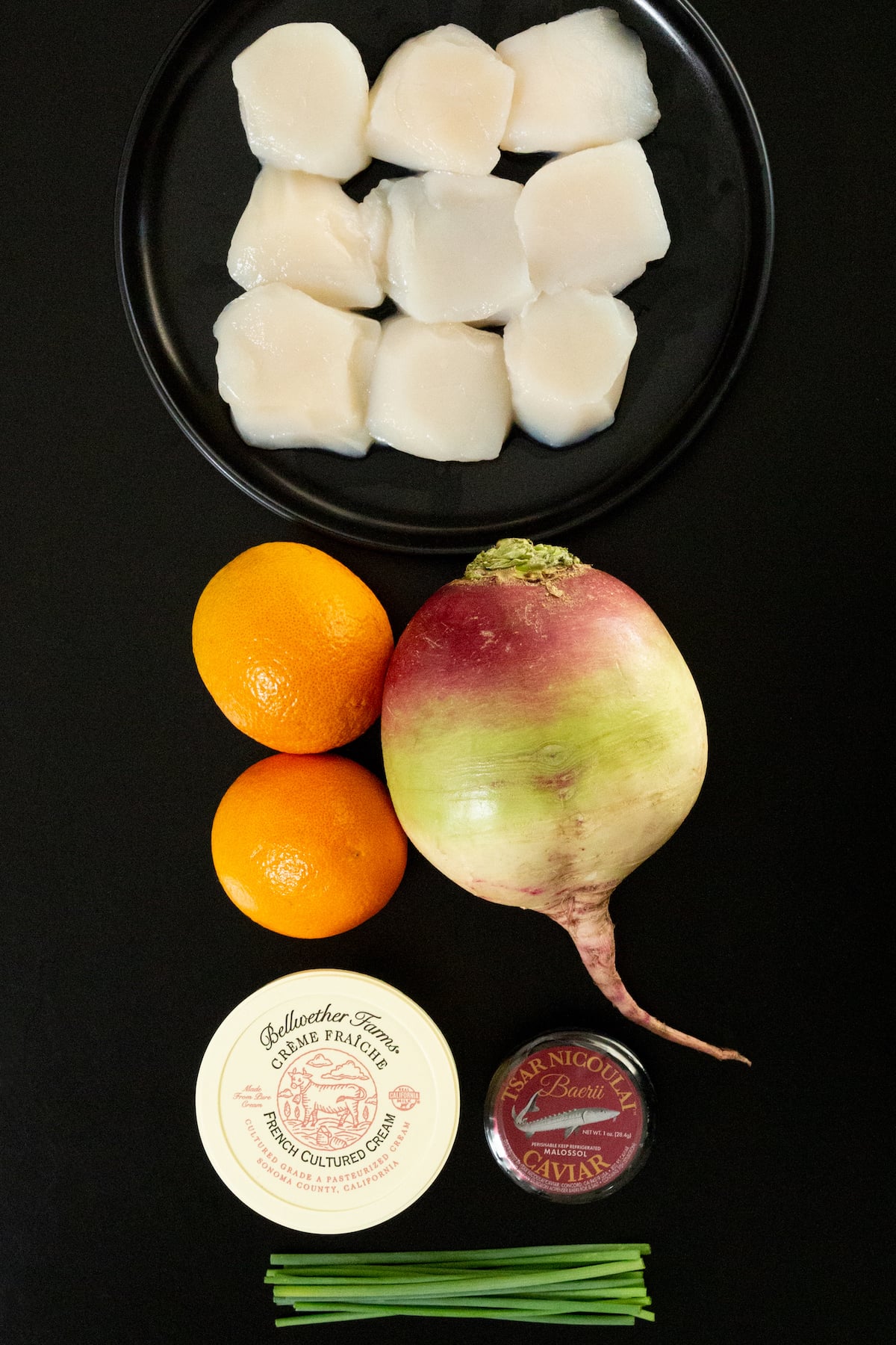 Nine jumbo scallops, two small blood oranges, a watermelon radish, a tub of creme fraiche, a small jar of caviar, and chives