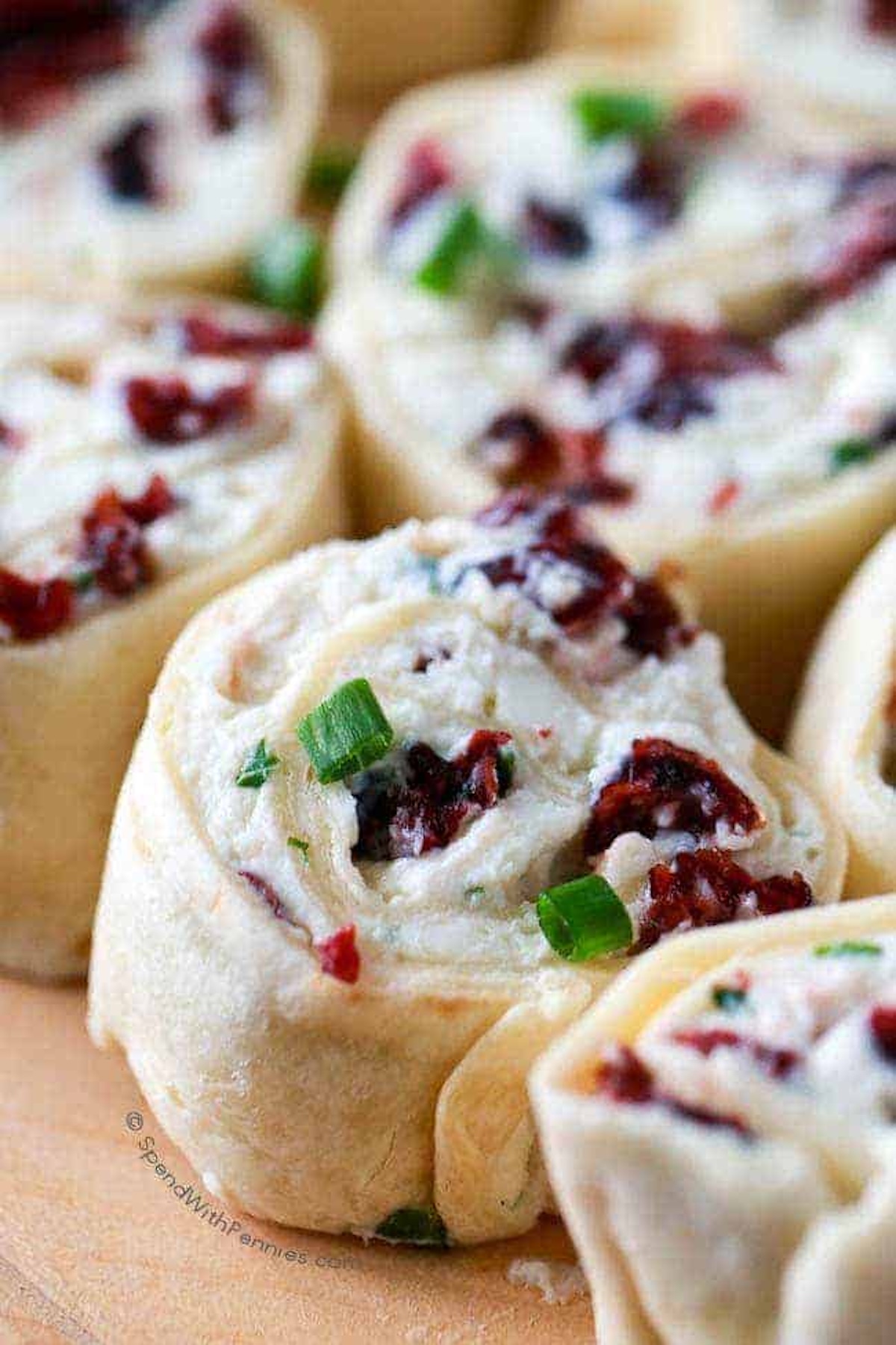 Pinwheels made with tortillas have been stuffed with a cream cheese, cranberry and green onion mixture.