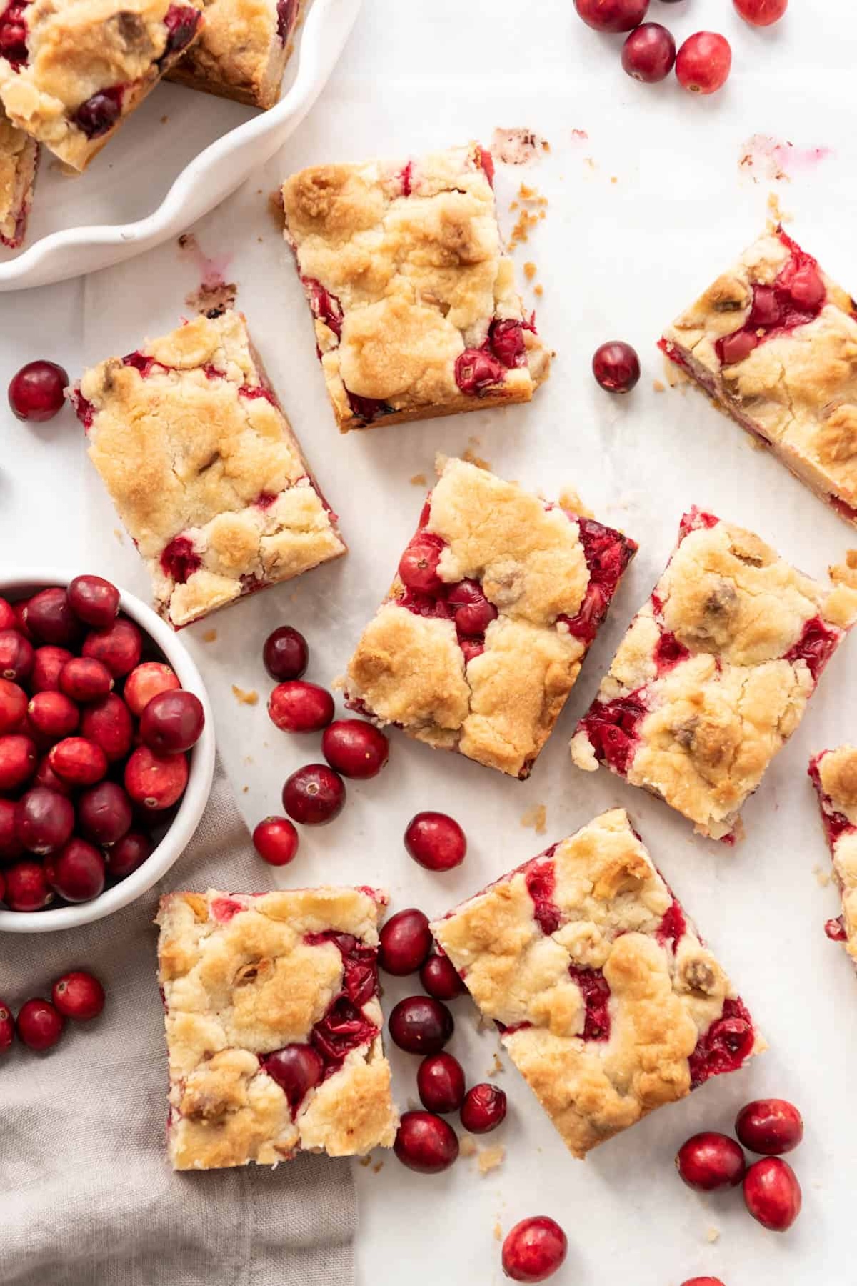 7 shortbread bars with fresh cranberries are surrounded by more cranberries.