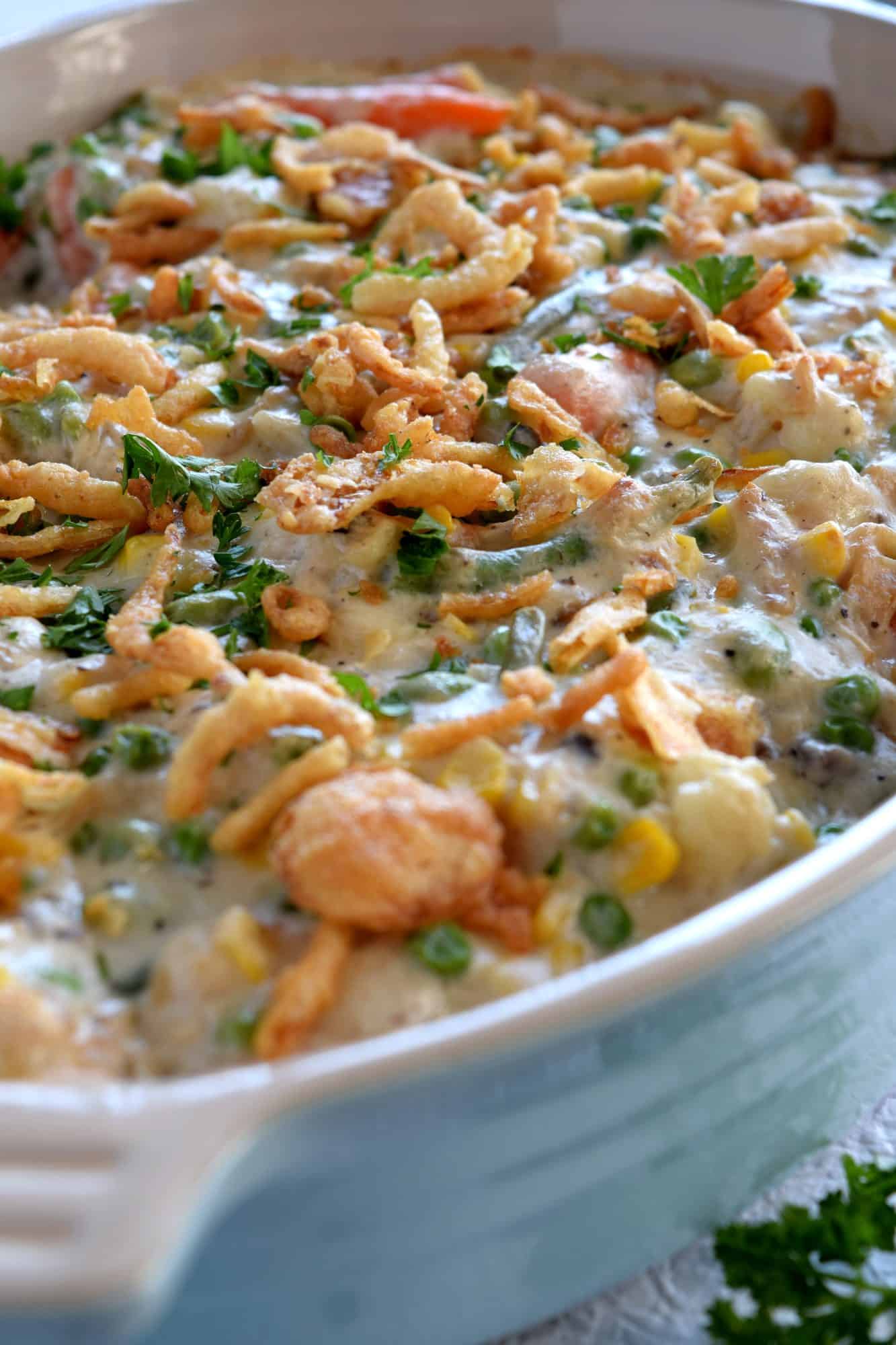A large, deep casserole dish filled with a creamy vegetable casserole that's topped with crispy onions.